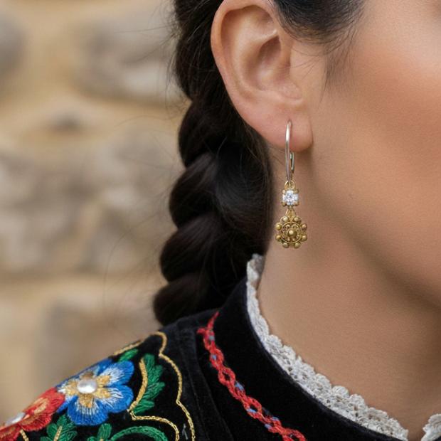 Boucles d'oreilles bouton Charro plaqué or avec moissaniteReferencia: PE3362Boucles d'oreilles en plaqué or accompagnées d'une moissanite de 5 mm à taille brillante.La moissanite est une pierre précieuse créée en laboratoire qui a gagné une place spéciale dans la joaillerie en raison de sa beauté et de ses qualités uniques. Elle éblouit par son éclat semblable à celui d'un diamant et par sa grande résistance (9,25 sur l'échelle de Mohs).Découverte à l'origine dans une météorite à la fin du 19e siècle, cette origine 