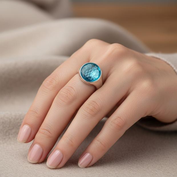 Bague en argent aux armoiries héraldiques gravées dans le cristalReferencia: SR0395Bague en argent sterling, avec cristal de couleur taillé en cabochon de 16 mm et armoiries héraldiques du nom de famille gravées au dos.